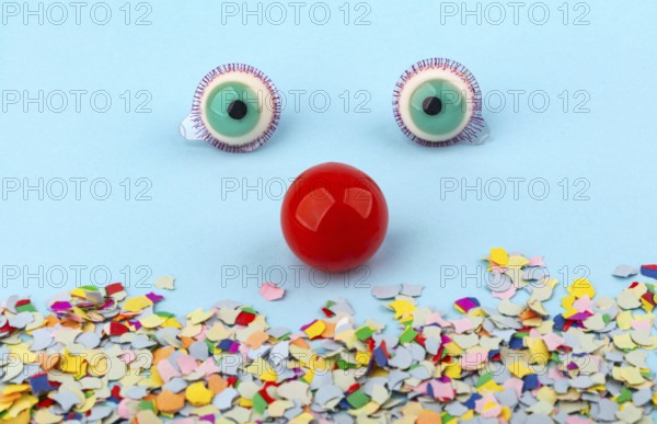 Red Nose with confetti over light blue background. Conceptual Photo to use for all funny