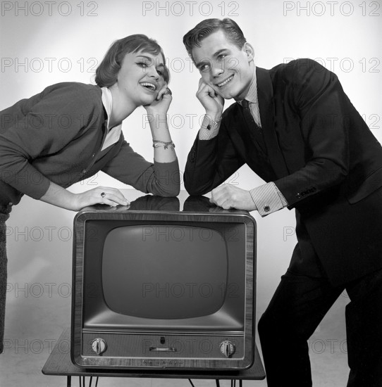 Television in the 1950s. A young couple is pictured beside a typical 50s television set. Photo
