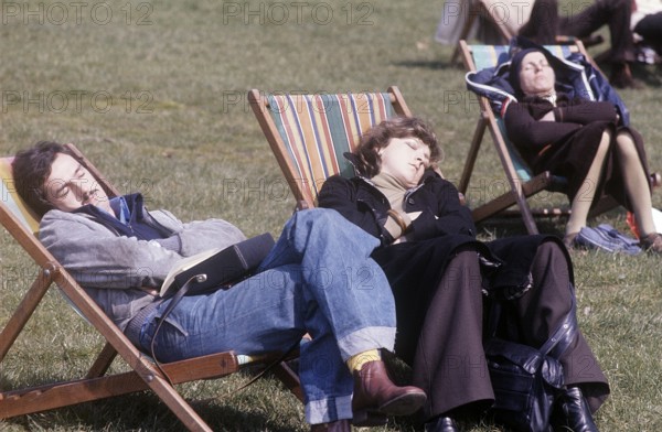 London 1982. A London park and people are sitting in chairs enjoying the sunny sping day. Credit