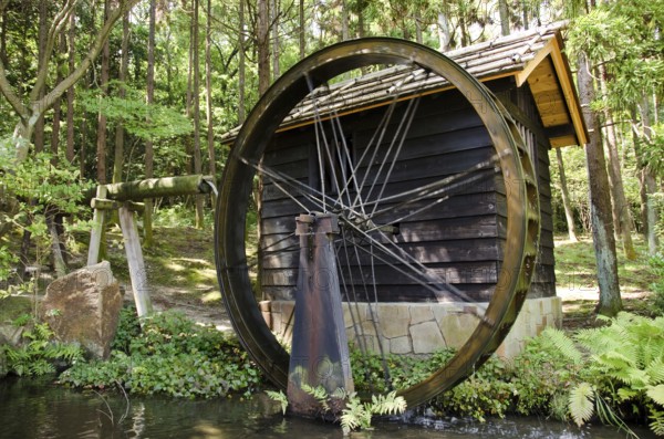Small Japanese water mill running in the Expo Commemorative Park, Osaka, Osaka, Japan, Asia