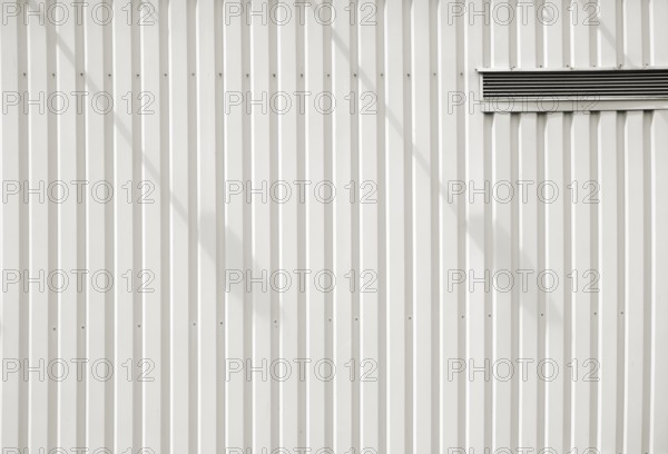 A modern façade of a shopping centre and DIY store made of checker plate with a ventilation slot