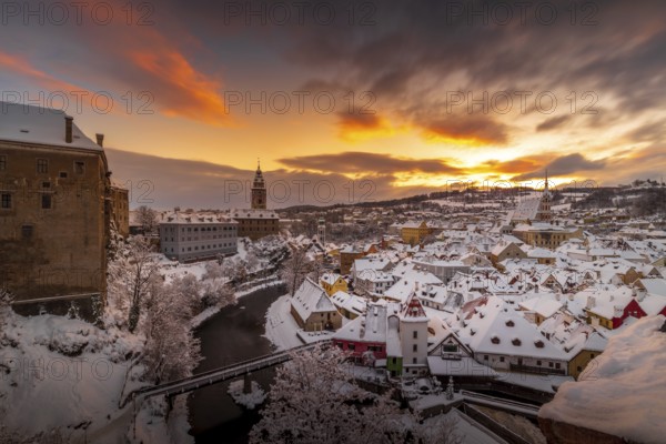 Winter view of Cesky Krumlov, picturesque houses under the castle with snow-covered roofs. Narrow