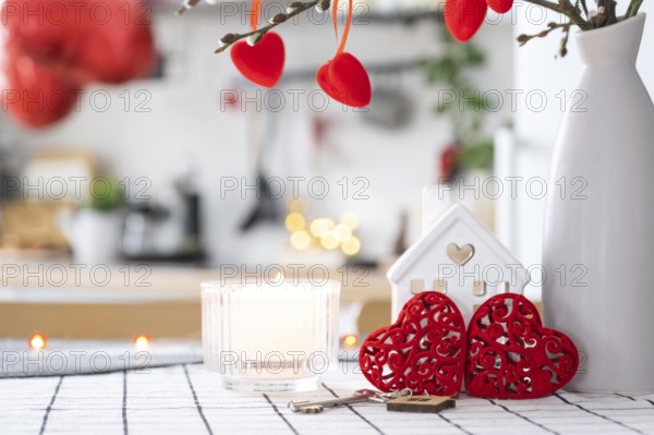 Key to house of cozy home with Valentine decor on table of kitchen. Gift for valentines day, family