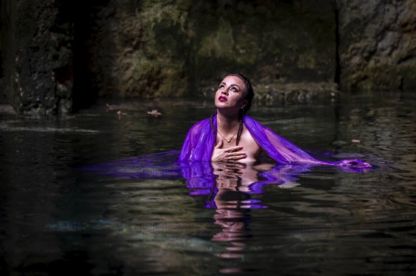 A beautiful nude latin model enjoys the gorgeous water in a colorful cenotes in Yucatan Merida,