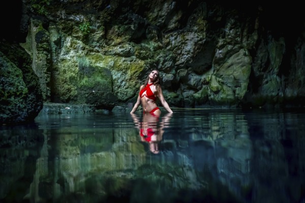 In Cuzama, Yucatan, Mexico, a stunning model revels in the vibrant hues of a cenote's blue and
