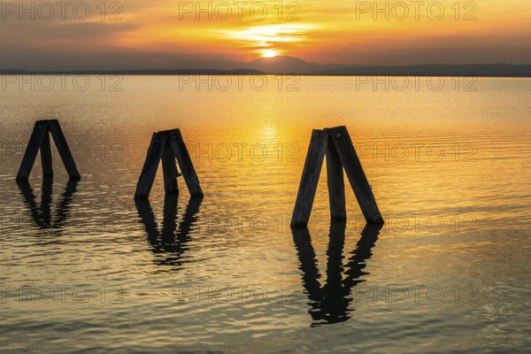 Evening atmosphere at the lake at sunset, bollard in Lake Neusiedl, Podersdorf, Burgenland,