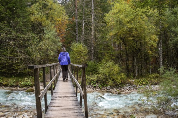 Crossing a wooden footbridge in the forest, somewhere in the Bistrice valley in the Triglav