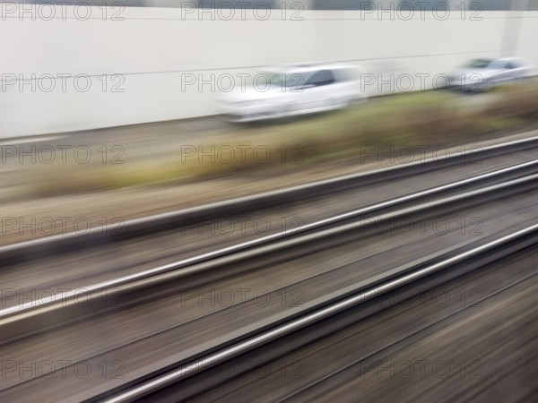 Tracks and rails in motion from a moving train. Symbolic photo for train journey, speed and