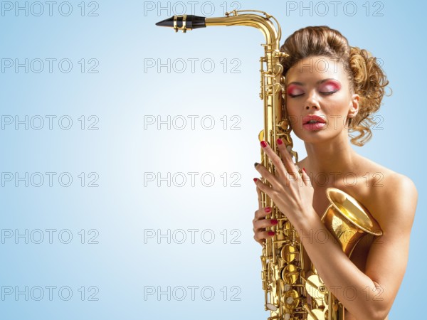 Retro photo of a sleepy naked pin up woman with closed vintage winged eyes embracing a saxophone