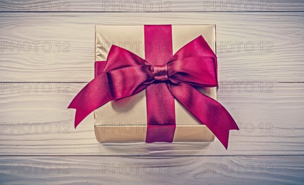 Wrapped present box on wooden board directly above holidays concept