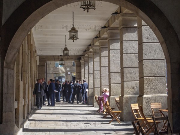 Group of businessmen under the colonnade of Cervantes Square, Santiago de Compostela, Galicia,