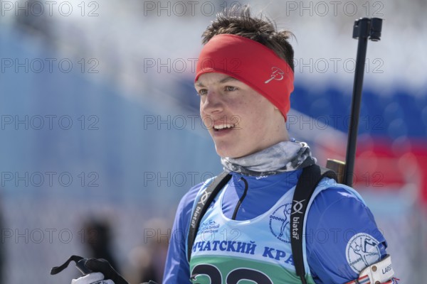 Portrait of sportsman biathlete Sporshev Nikita at finish after rifle shooting and skiing. Junior