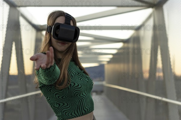 Young hispanic woman wearing in virtual reality goggles, touch something like push click on button,