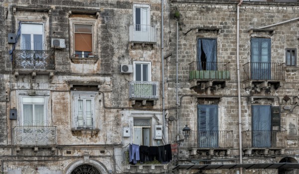 Taranto, Italy, 30 November, 2023: shabby chic derelict buildings with laundry hanging from the