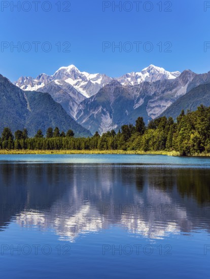 The forests and Mount Cook and Mount Tasman. Magnificent snow-capped mountains surround the smooth,