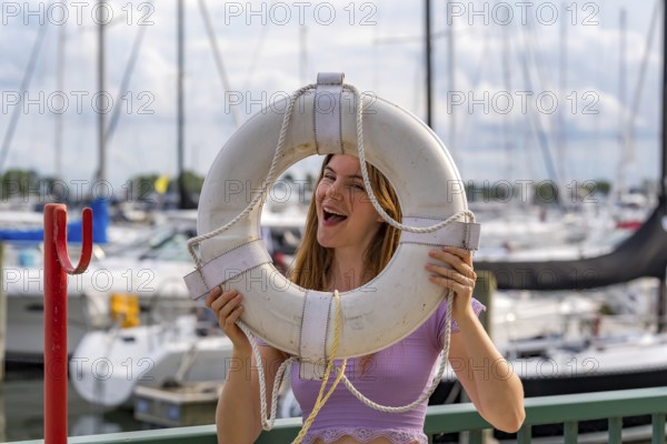 A gorgeous redhead model enjoys the perfect summer weather at a local marina, surrounded by boats