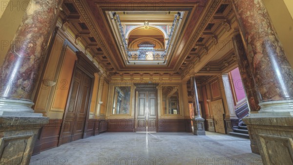 A magnificent corridor with marble columns and richly decorated ceilings in warm colours, Villa