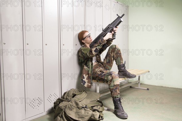 A shoot of young caucasian beautiful redhead woman sitting on the bench at locker room. ?hecking