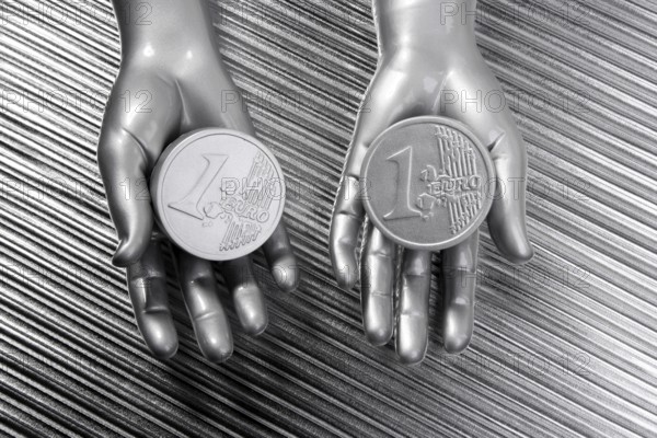 Two silver euro coins in futuristic robot gray metallic hands bank metaphor