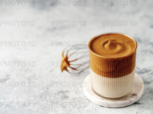 Trendy korean drink - dalgona coffee. Glass jar with cold or hot beverage - whipped instant coffee