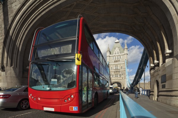 The famous Tower Bridge in London, UK. Double-decker bus passes under the arch of the tower. Sunny