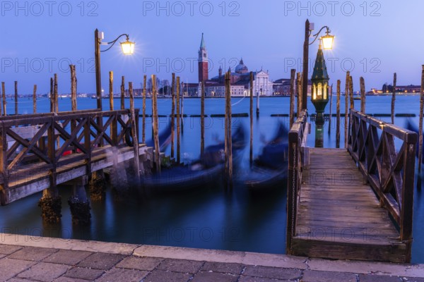 Venetian gondolas, boat dock at St Mark's Square, church of San Giorgio Maggiore in the background,