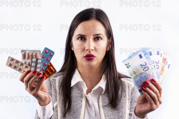 Different colorful pills and capsules in blisters and euro banknotes in the hands of angry young