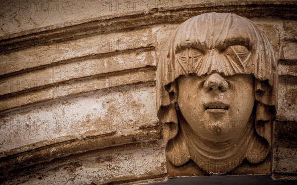 Gothic detail. Young woman portrait at the entrance of a 200 years old building in Ciutadella town,