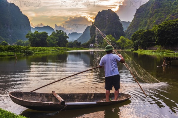 Fisherman on boat in Trang An, a scenic area near Ninh Binh, Vietnam inscribed as a UNESCO World