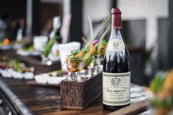 Bottle of red bourgogne wine at oudoor party bar counter