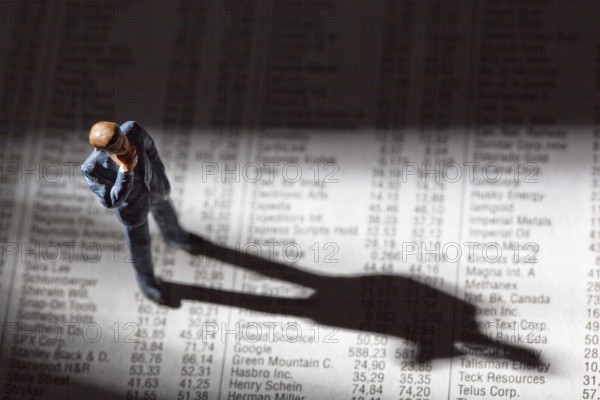 A small figure and the prices of shares in a newspaper. Earning money on the stock market. Profits