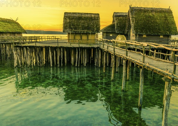 Fishing huts made from wood, clay and thatched roof, suspended on stilts over a lake water, with