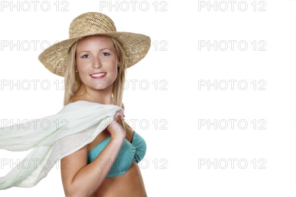 A pretty young woman in summer with a straw hat and bikini is looking forward to her holiday.