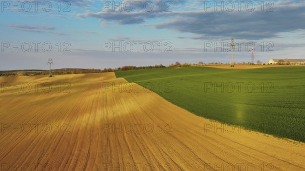 Aerial view of amazing green wavy hills with agricultural fields in evening spring. South Moravia