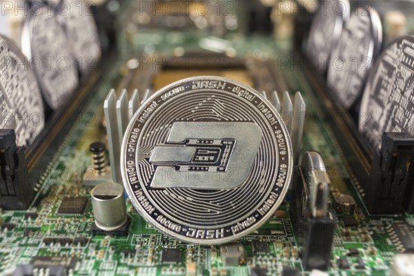 Dash coin close-up on a computer circuit motherboard as a blockchain technology payment network.