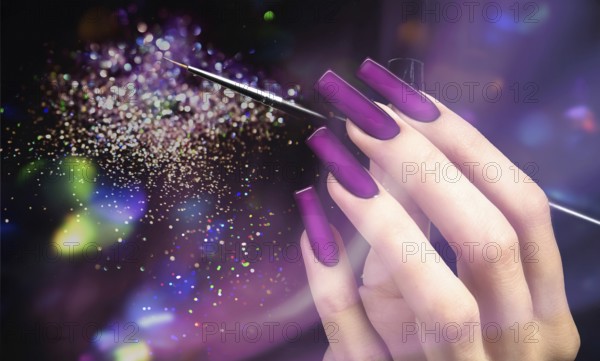 Hand with a beautiful manicure and a brush on a purple bokeh background. Nail design. Extended