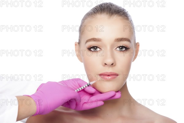 Beautiful face lip filler collagen injection Cosmetic spa beauty treatment with pink gloves, on