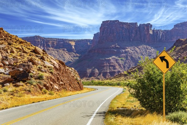 Wide asphalt highway among picturesque hills and rocks of bizarre shapes. The grandiose landscapes