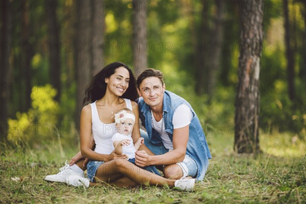 The theme family outdoor recreation in forest park area. Young beautiful stylish caucasian family