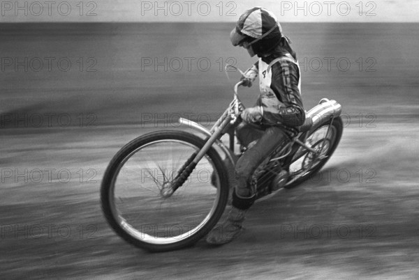 Speedway driver in the 1970s. The speedway motorcycle and driver is pictured racing on the speedway