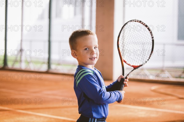 Child playing tennis on outdoor court. September 20, 2016, Ukraine, Kiev. Little tennis great