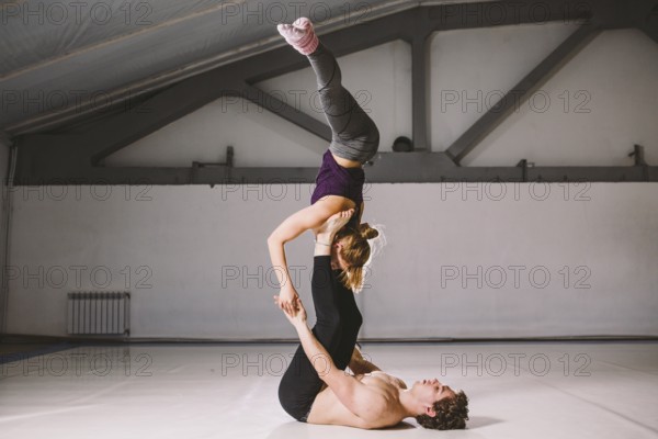 Yogi couple practice. Couple young sporty peoplepracticing acrobatic yoga lesson with partner, man
