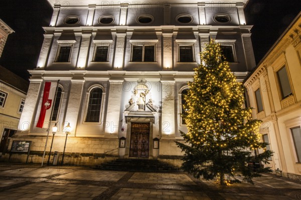 Illuminated Christmas tree in front of church, St. Xaver parish church, night shot, Leoben, Styria,