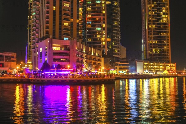 Dubai Marina Walk illuminated at night. Dubai Marina is a newly futuristic district, famous for