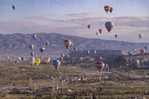 A picture of colorful hot air balloons flying over the landscape of Goreme Historical National Park