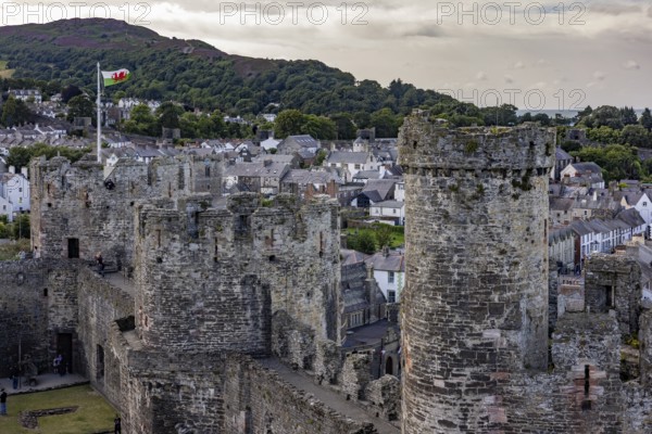 Conwy Castle, medieval castle with towers and surrounding town in a green landscape under a cloudy