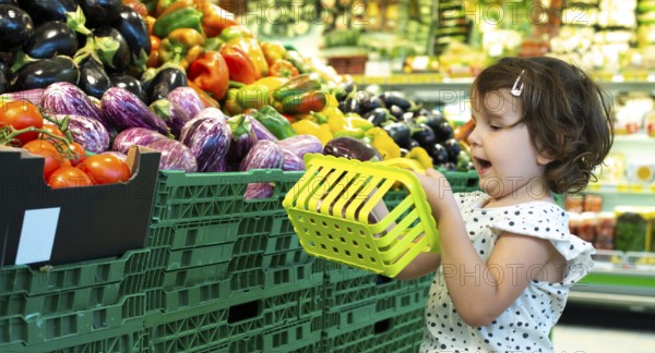 Child shopping eggplants in supermarket. Concept for buying fruits and vegetables in hypermarket.