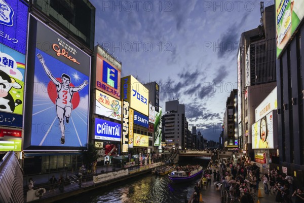 OSAKA, JAPAN - SEPTEMBER 24 2024: The view down Dotonbori River from Ebisubashi Bridge on a clear