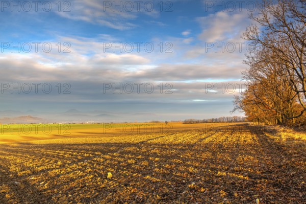 Autumn morning landscape over the city of Louny. Autumn plowed field at amazing sunrise. Czech