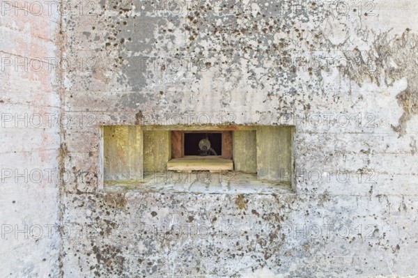 Closeup of an old machine gun opening in a old concrete WW2 bunker with machine gun, Hostikka,